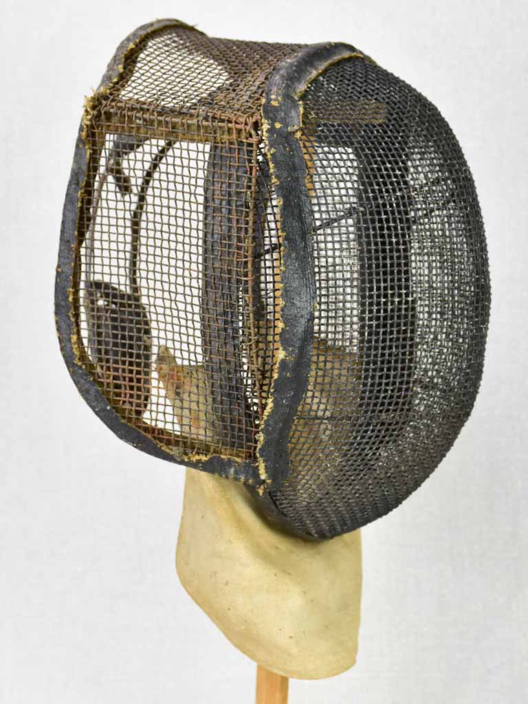 Collection of three antique French fencing masks on vintage hat stands