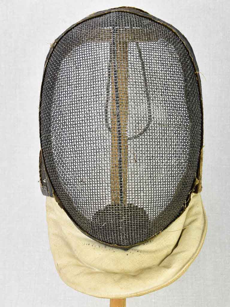 Collection of three antique French fencing masks on vintage hat stands