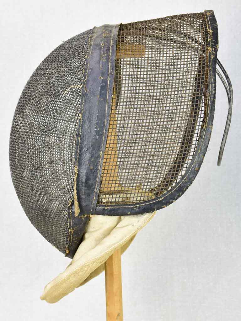 Collection of three antique French fencing masks on vintage hat stands