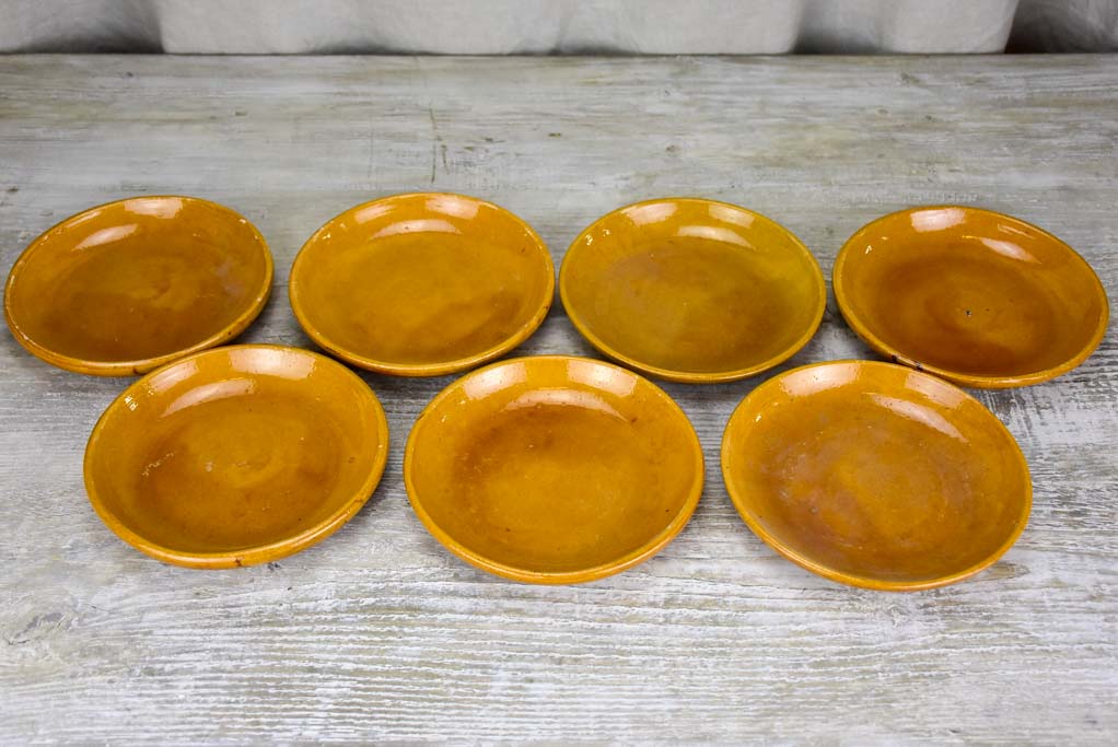 Set of seven mid-century plates with ocher glaze