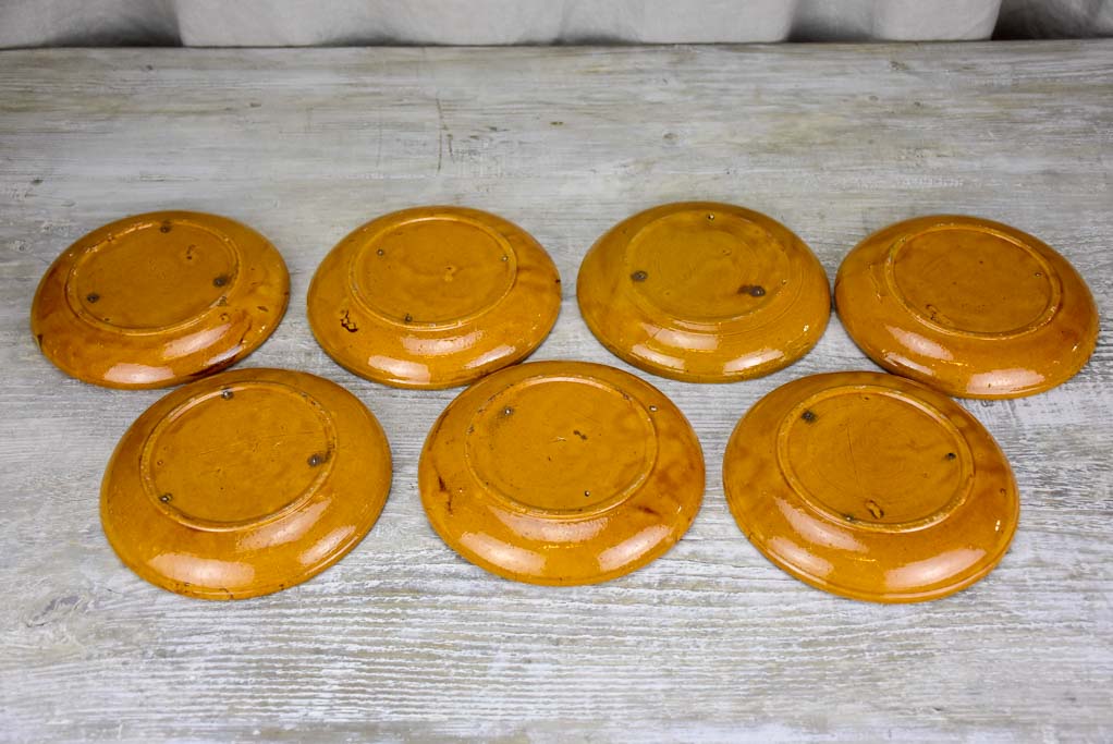 Set of seven mid-century plates with ocher glaze