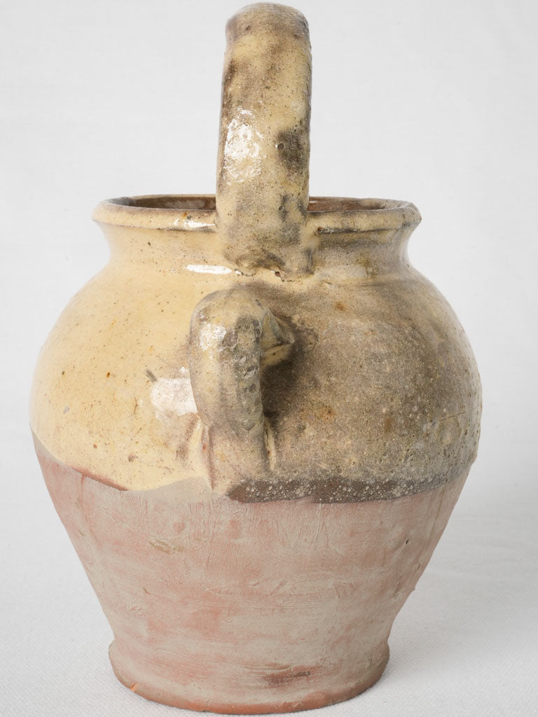 Aged terracotta ewer with yellow glaze