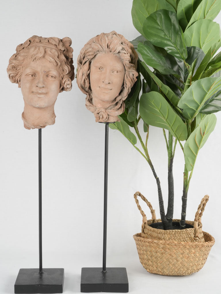 Antique terracotta busts on iron stems
