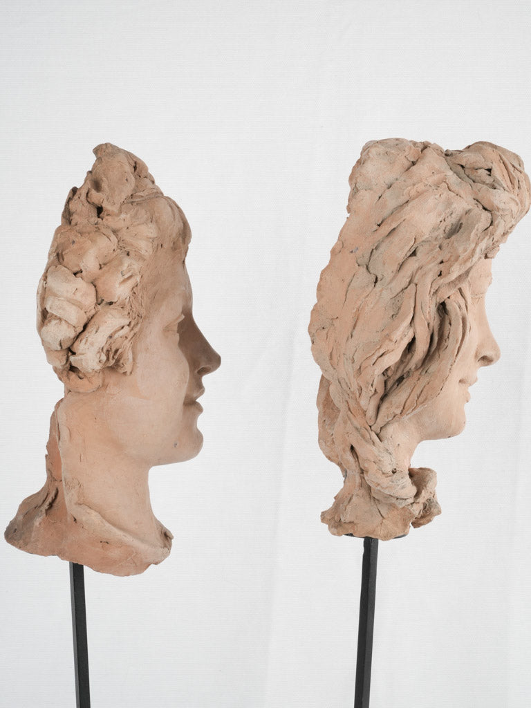 Time-worn terracotta heads, stem-mounted