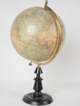 Aged world globe on brass stand