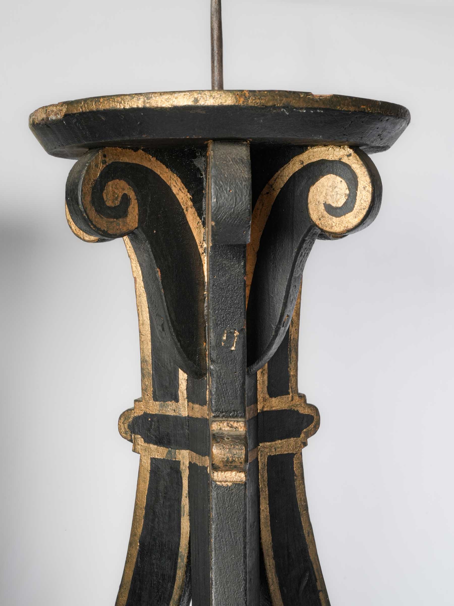 Black-painted ochre-detailed torchère stands  