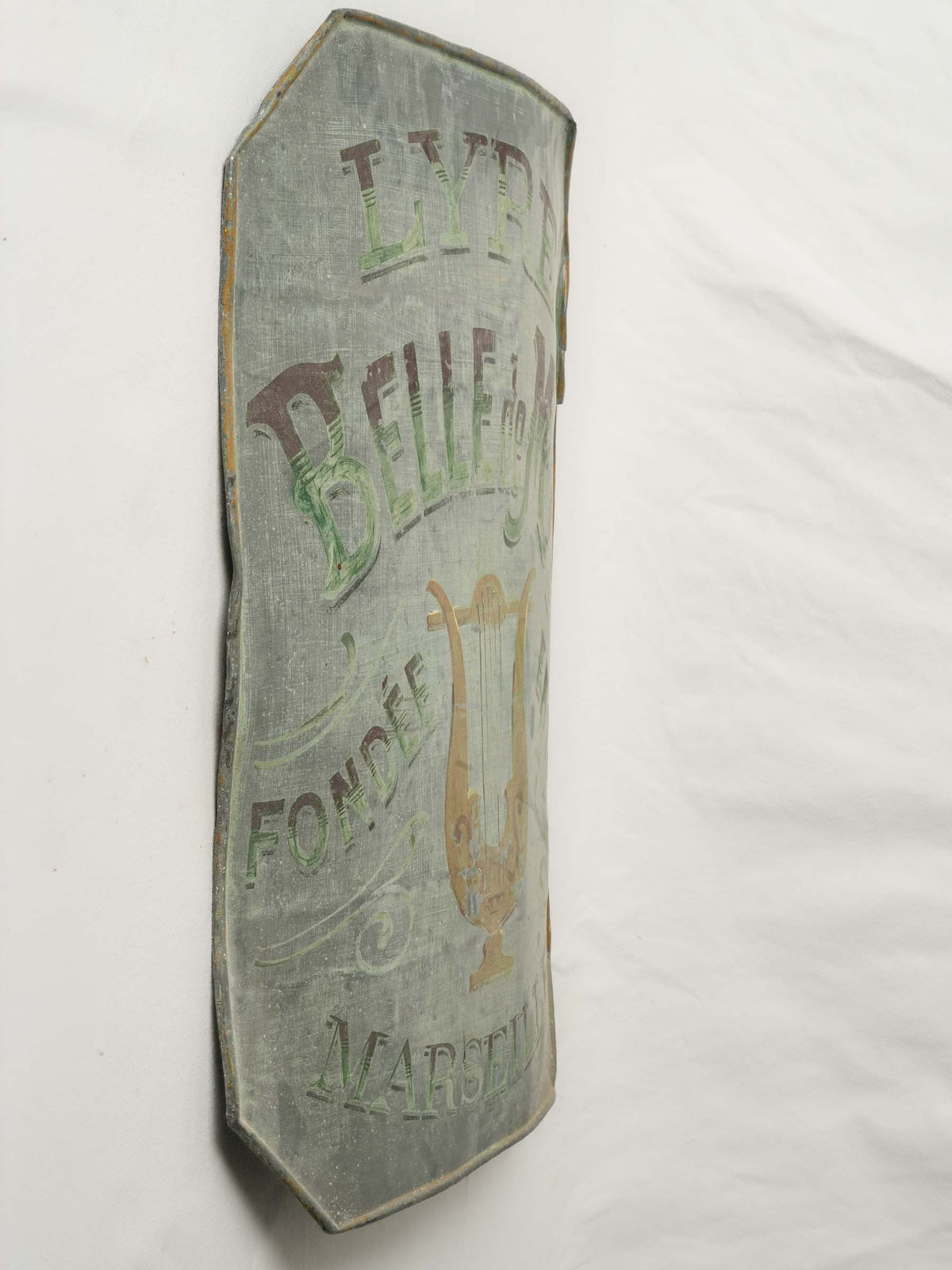 Weathered green-gray lyre emblem  