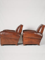 Classic piped-edge leather lounge chairs