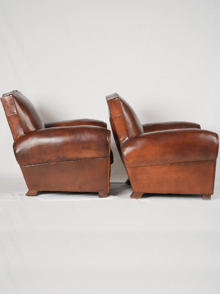 Aged leather comfortable club armchairs