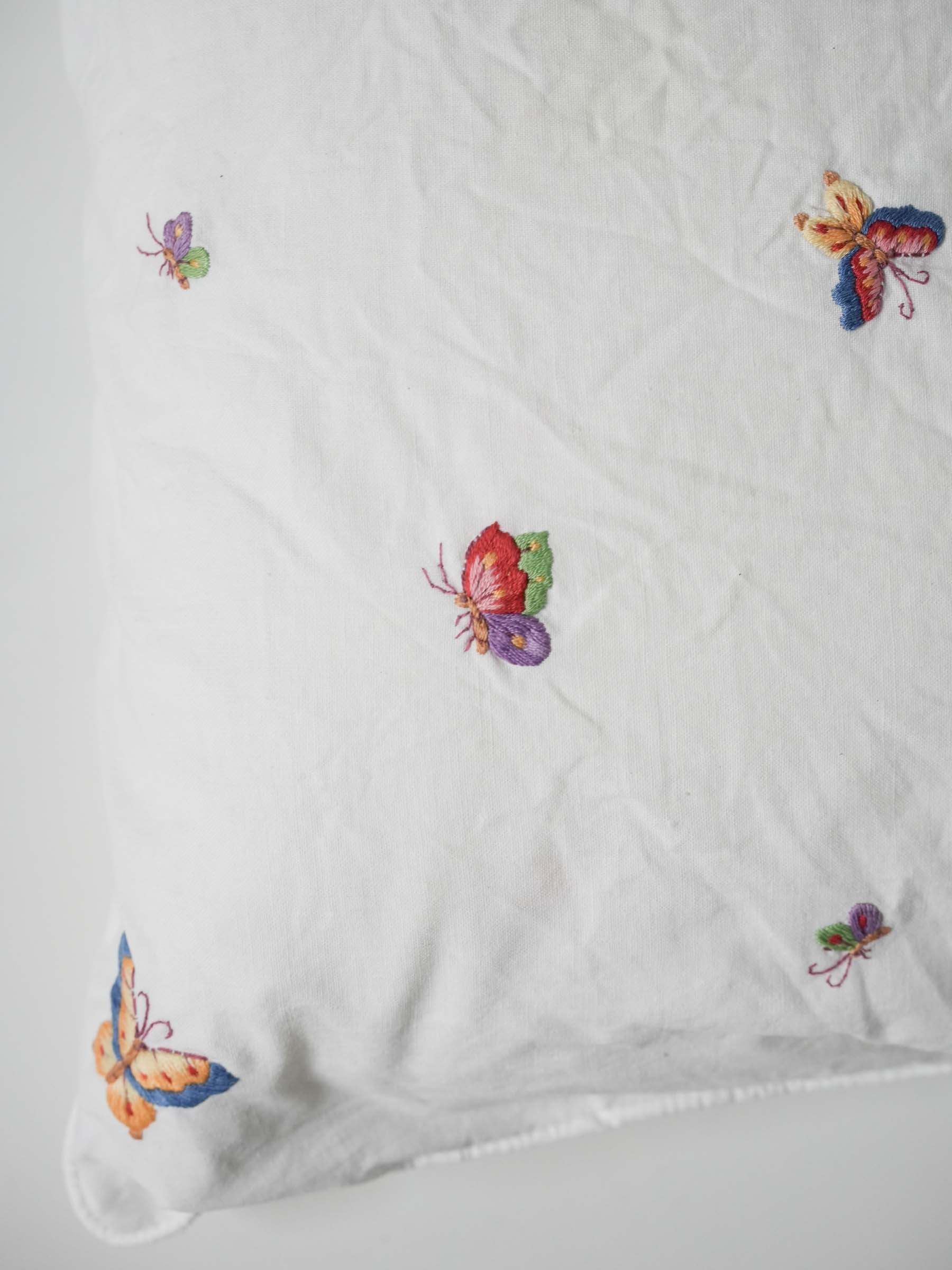 White pillowcase embroidered with colorful butterflies