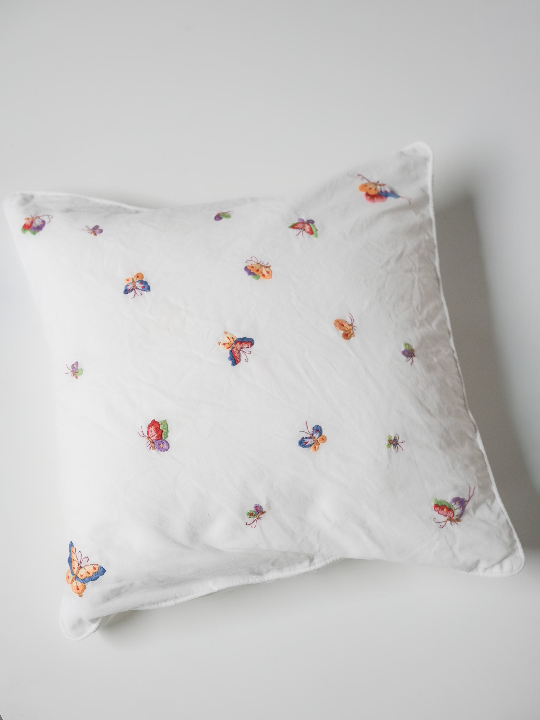 White pillowcase embroidered with colorful butterflies