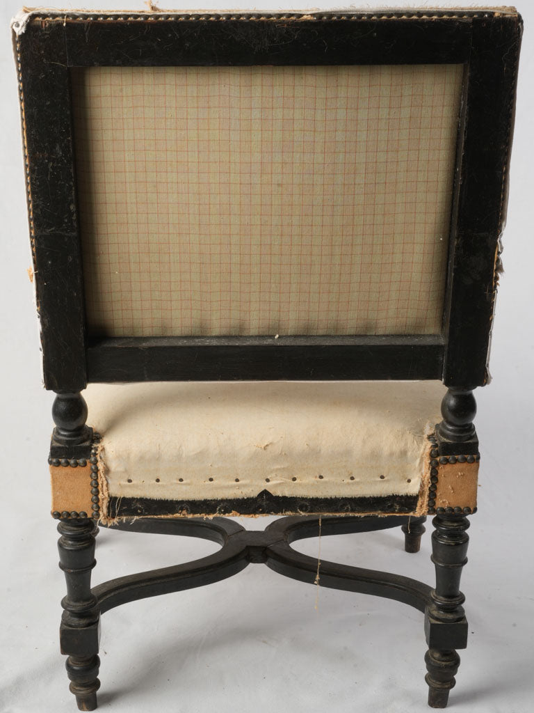 Scuffed ebonized wood armchair