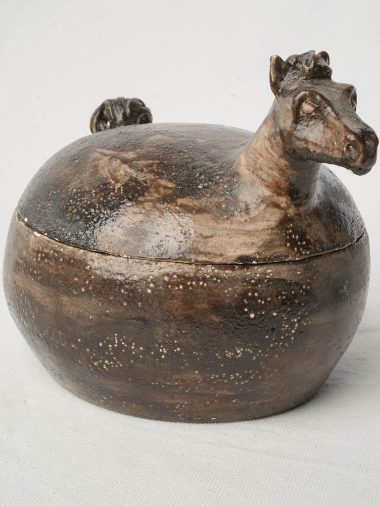 Stylized earthy-colored lidded container  