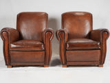 Classic 1940s barrel-armrest leather chairs