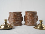 Weathered brass-lidded tobacco containers