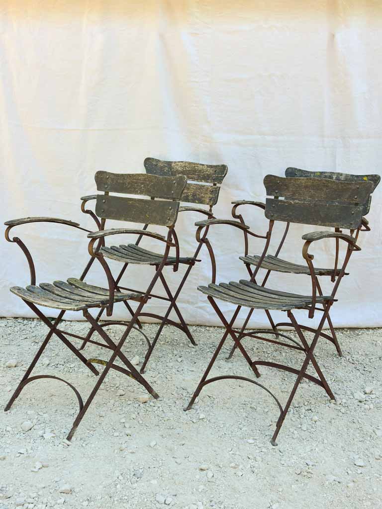 Four antique French iron and timber slatted garden armchairs