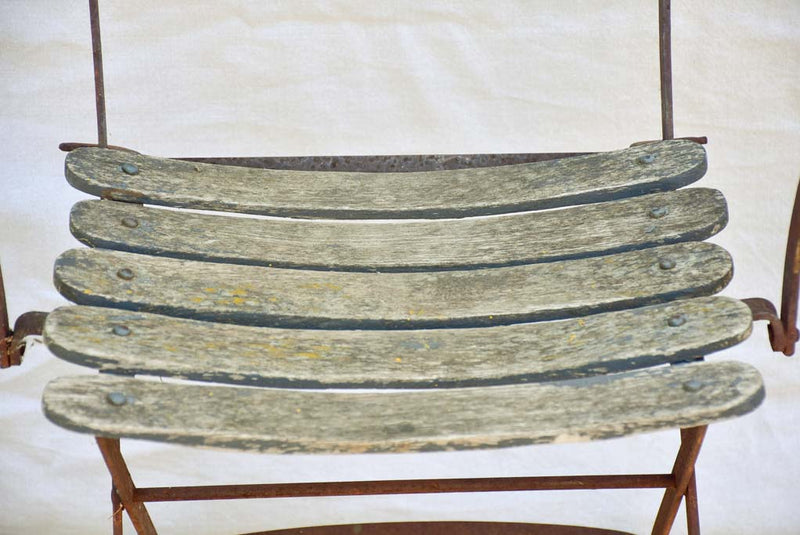 Four antique French iron and timber slatted garden armchairs