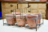 Collection of six terracotta pots in a wire bottle carrier