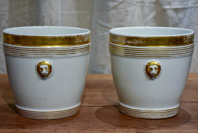 Pair of antique French porcelain pot stands with gold lion's heads