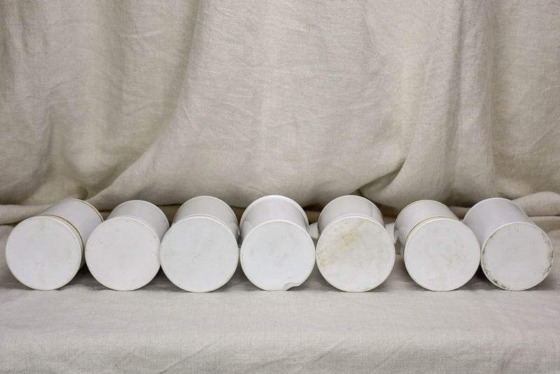 Collection of 7 white antique French apothecary jars with lids
