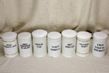 Collection of 7 white antique French apothecary jars with lids