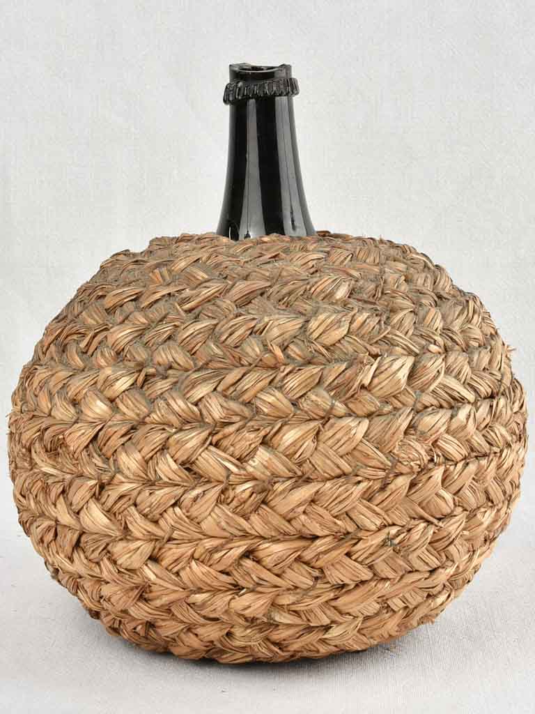Small demijohn bottle in woven straw basket 12¼"