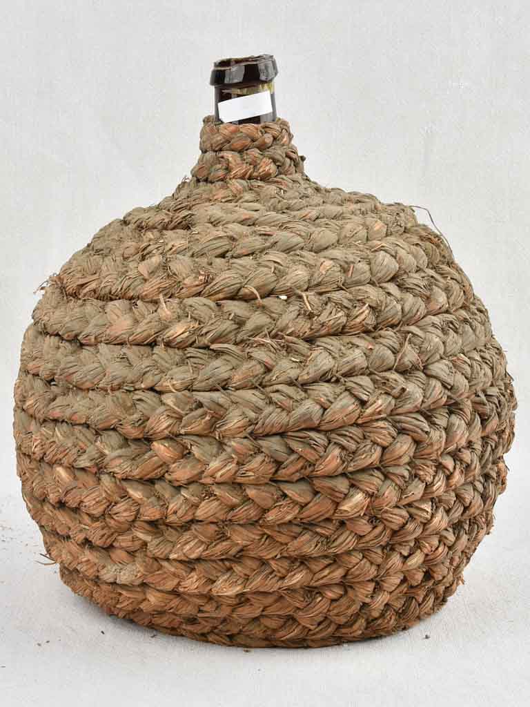 Medium demijohn bottle in woven straw basket 13¾"