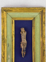 18th Century sculpted wooden Christ on blue fabric with a green and gold frame 11¾" x 18½"