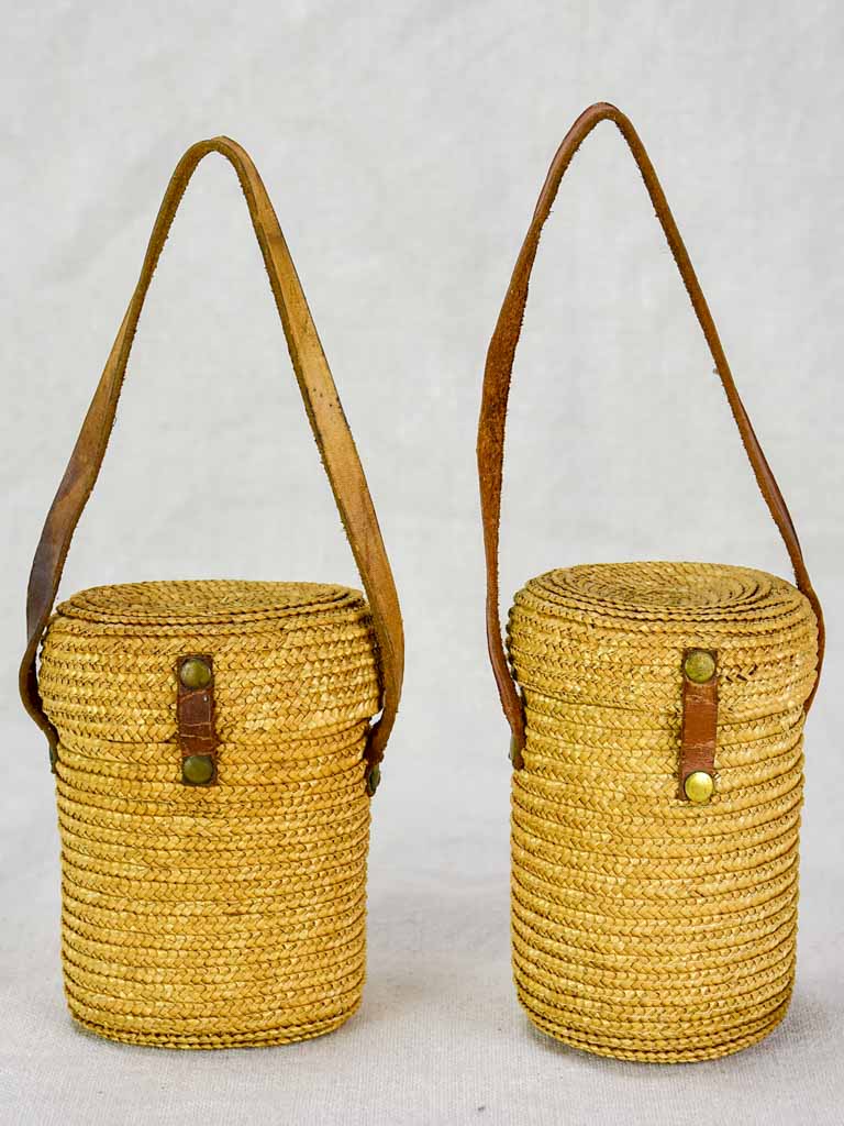 Two mid century French 'verre de cure' glasses in baskets