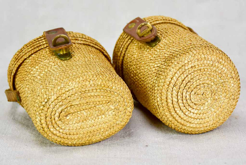 Two mid century French 'verre de cure' glasses in baskets