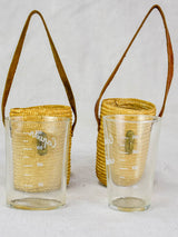 Two mid century French 'verre de cure' glasses in baskets