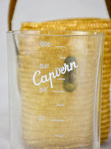 Two mid century French 'verre de cure' glasses in baskets