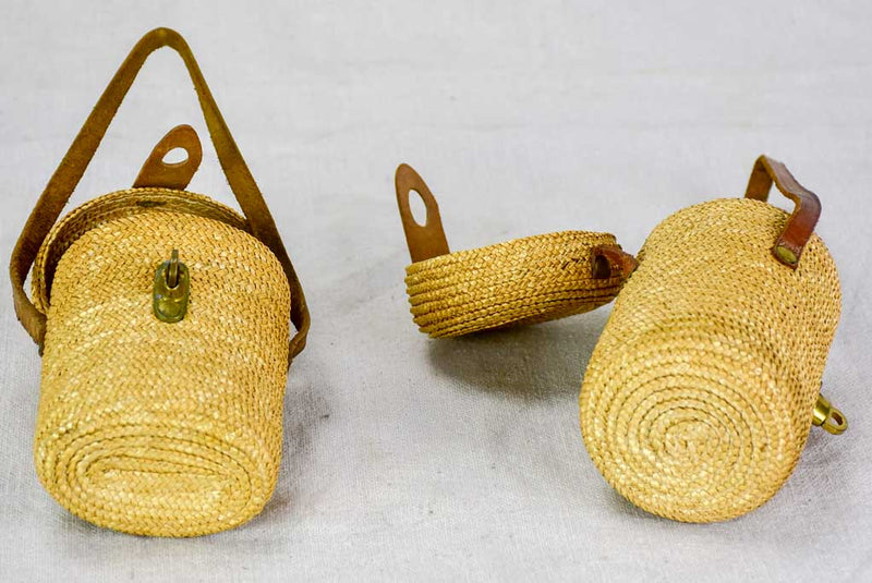 Two mid century French 'verre de cure' glasses in baskets