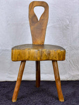 Antique primitive milking chair with three legs and teardrop back