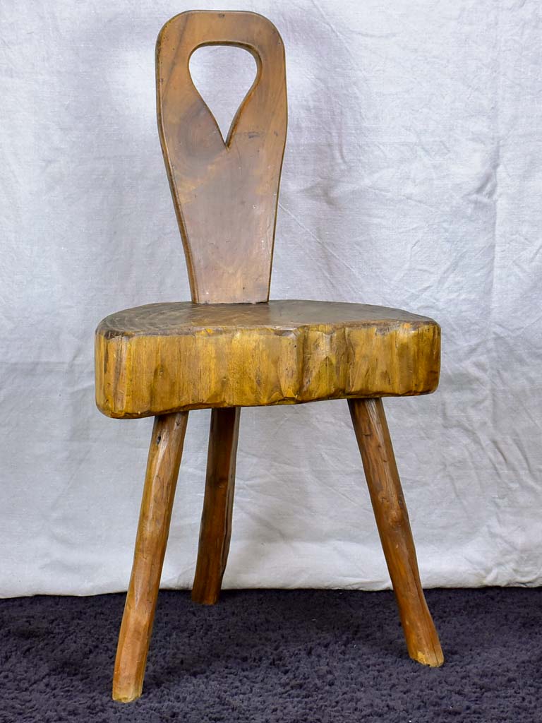 Antique primitive milking chair with three legs and teardrop back