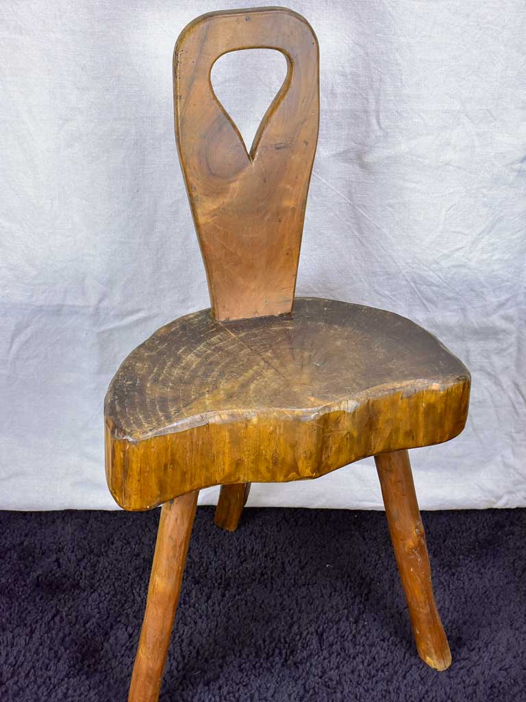 Antique primitive milking chair with three legs and teardrop back