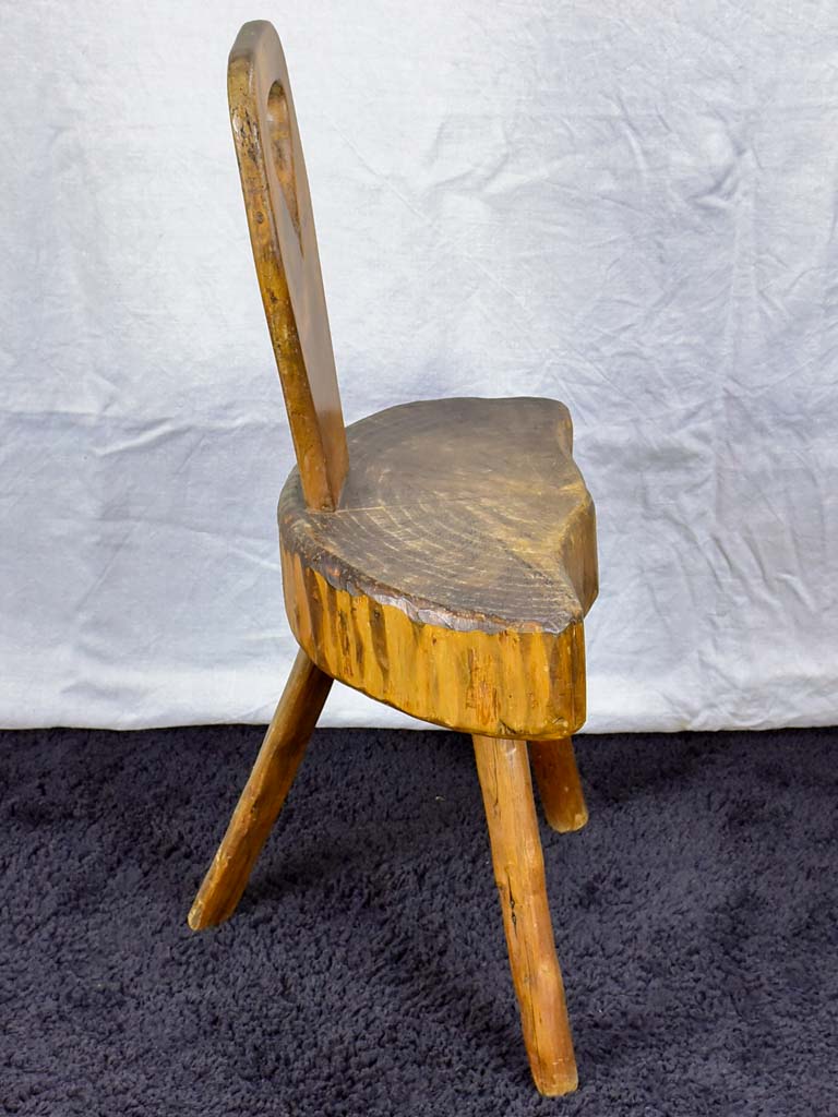 Antique primitive milking chair with three legs and teardrop back