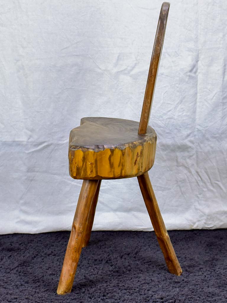 Antique primitive milking chair with three legs and teardrop back
