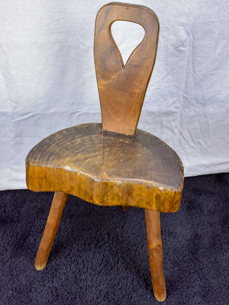 Antique primitive milking chair with three legs and teardrop back