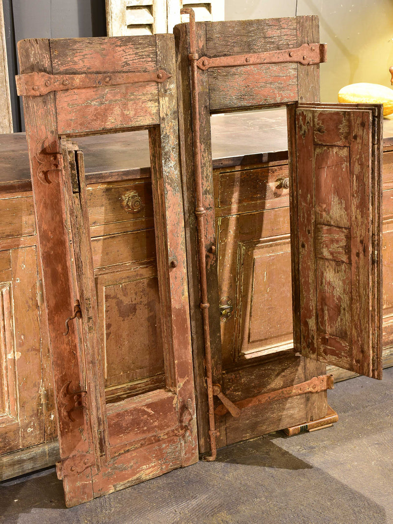 Pair of antique French shutters with original hardware and red patina