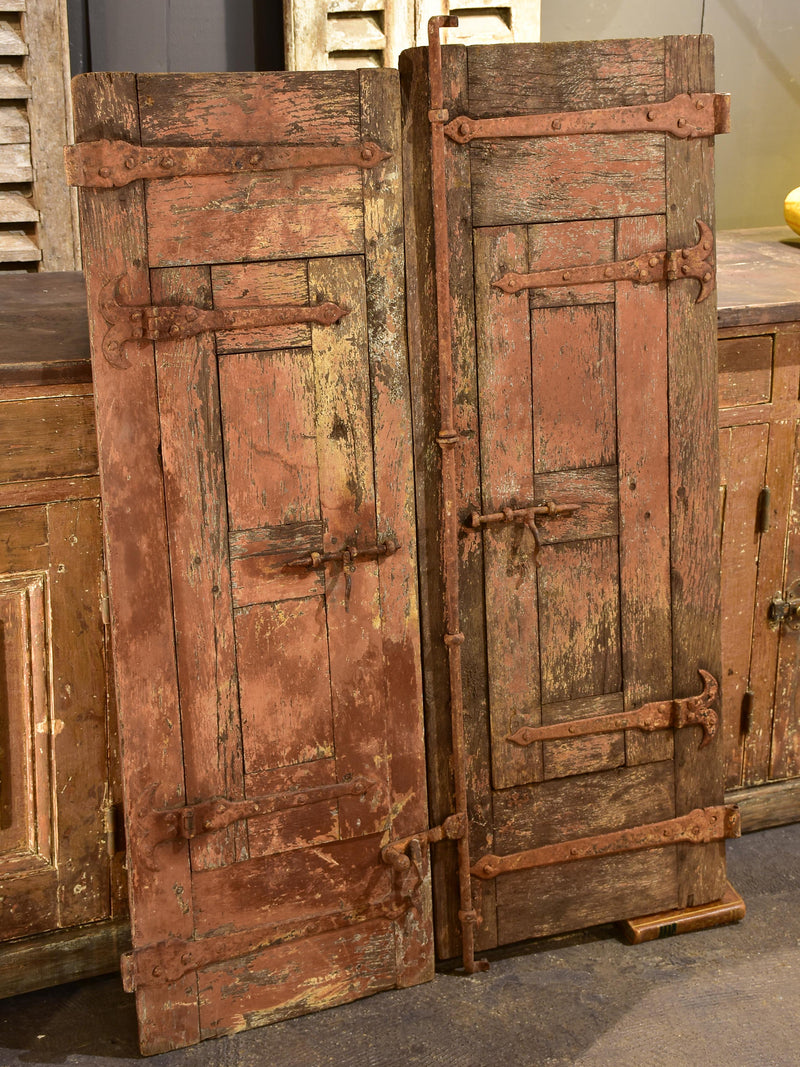 Pair of antique French shutters with original hardware and red patina