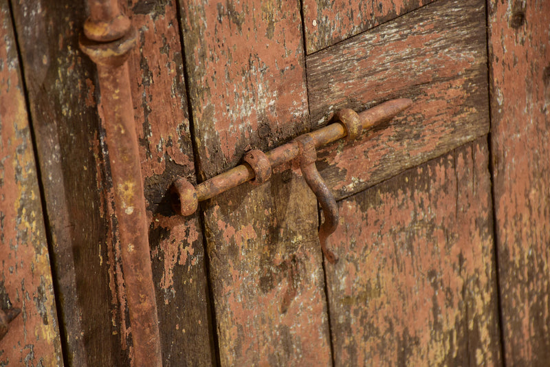 Pair of antique French shutters with original hardware and red patina