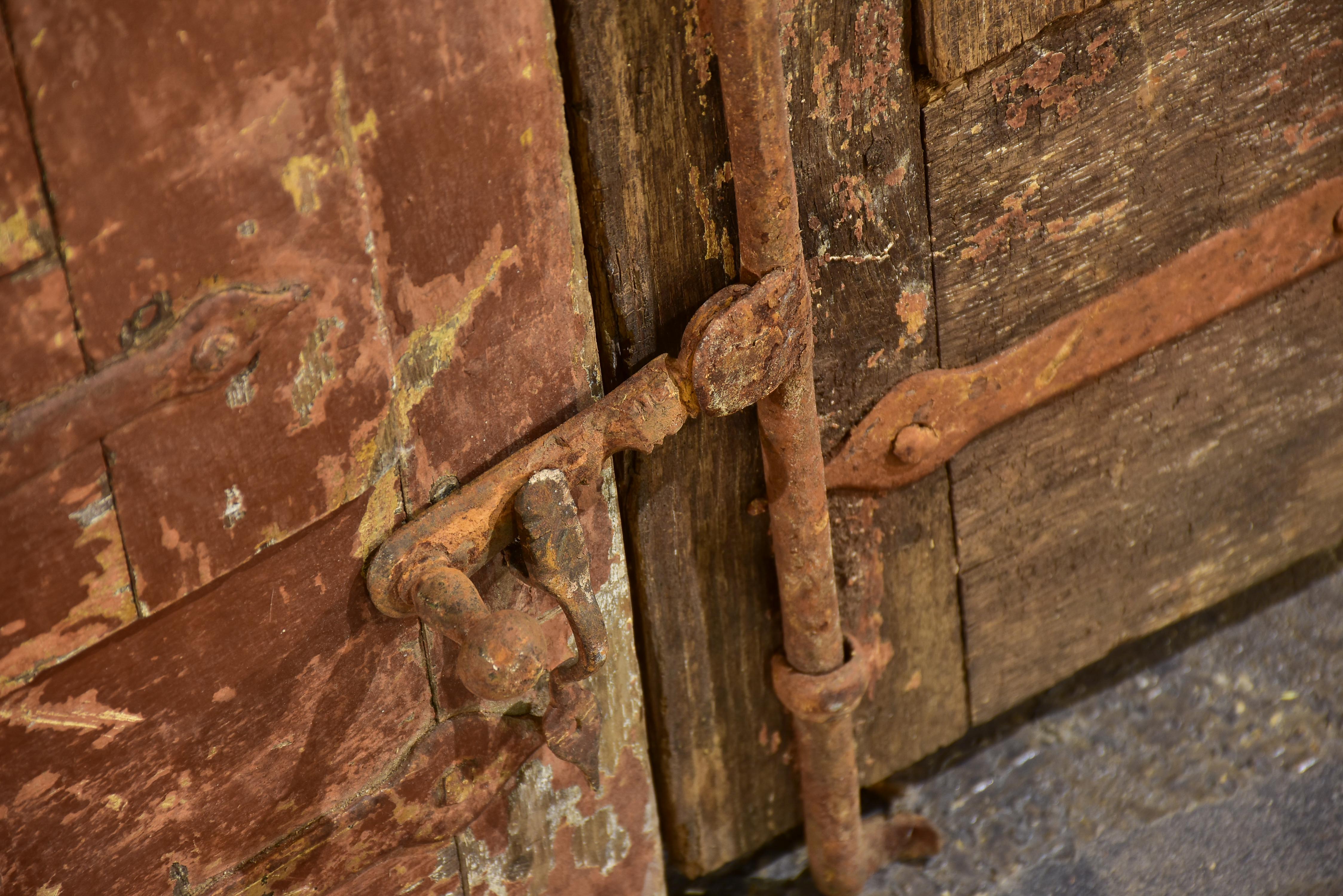 Pair of antique French shutters with original hardware and red patina