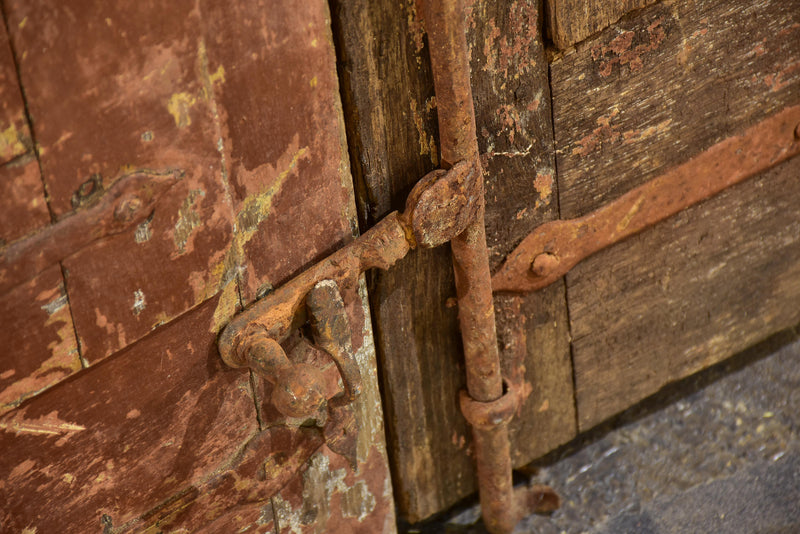 Pair of antique French shutters with original hardware and red patina