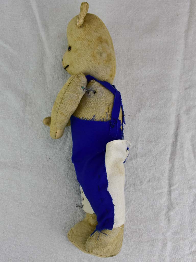Antique French teddy bear with blue overalls