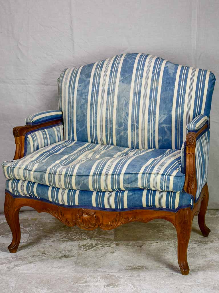 Large antique French Provincial armchair with striped blue and white upholstery walnut frame