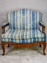 Large antique French Provincial armchair with striped blue and white upholstery walnut frame
