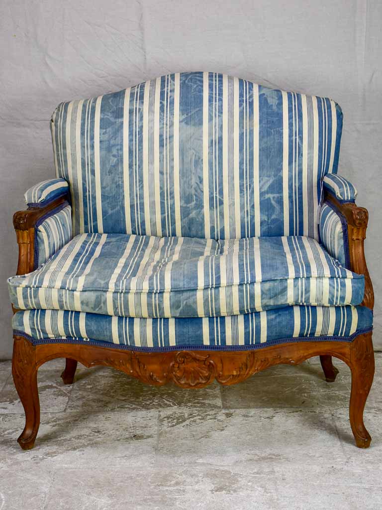 Large antique French Provincial armchair with striped blue and white upholstery walnut frame
