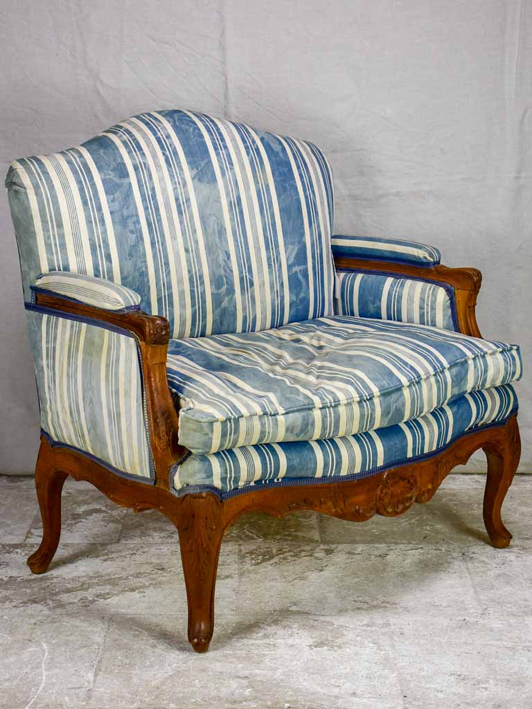 Large antique French Provincial armchair with striped blue and white upholstery walnut frame