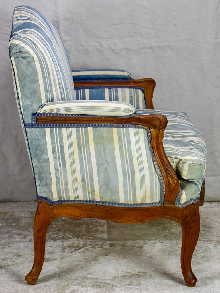 Large antique French Provincial armchair with striped blue and white upholstery walnut frame